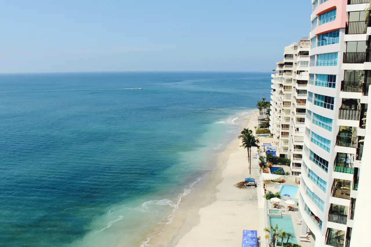 Oceanfront high-rises beside a turquoise beach.